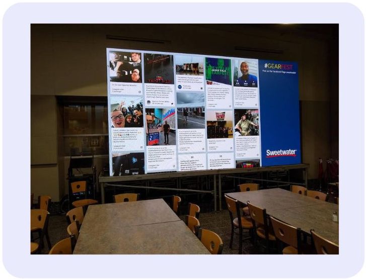 A large social wall display at Sweetwater GearFest featuring attendee-generated content on a screen in a dining area. (event marketing examples)